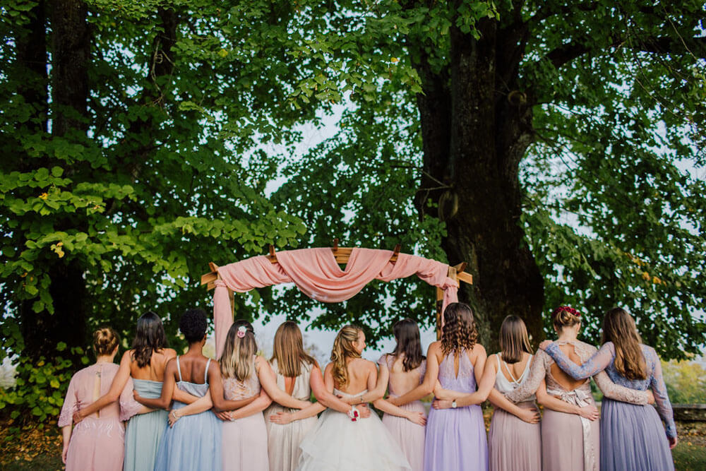 bride with her bridesmaids wearing pastel dresses in a chateau wedding in france