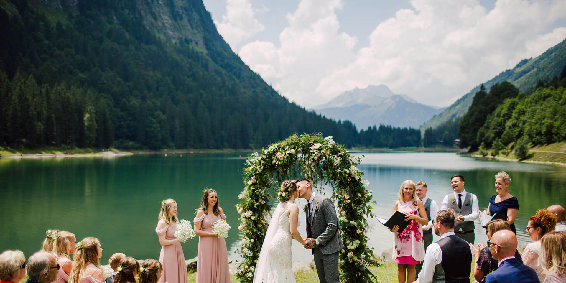 bride and groom kissing on their alpine lake wedding in montriond