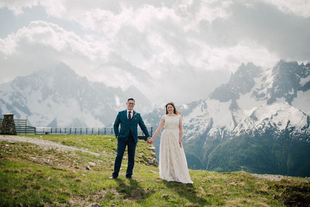 couple at the top of a mountain celebrating their elopement facing the mont blanc in the french alps